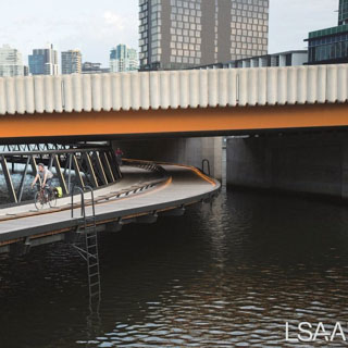 View of the curved Jim Stynes Bridge - Melbourne - passing underneath existing road bridge.